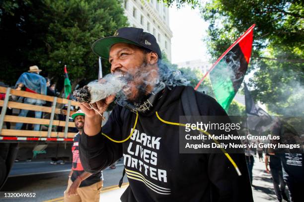 Erik Hardeman burns sage to peacefully cleanse the area during a Black Lives Matter march through downtown Los Angeles on the first anniversary of...