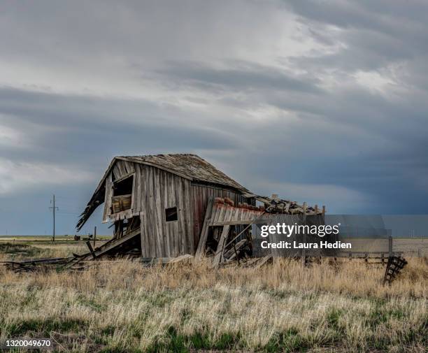 old abandoned structures on the great plains with impending storms - old barn stock pictures, royalty-free photos & images