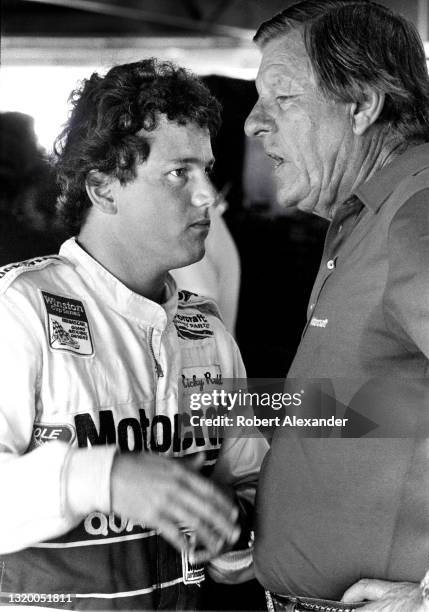 Driver Ricky Rudd talks with racecar owner Bud Moore in the speedway garage area prior to the start of the 1985 Pepsi Firecracker 400 NASCAR race at...