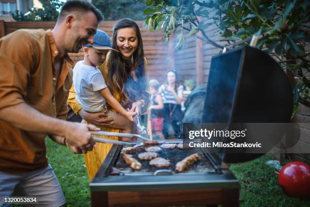 grillparty im hinterhof - grill zubereitung stock-fotos und bilder