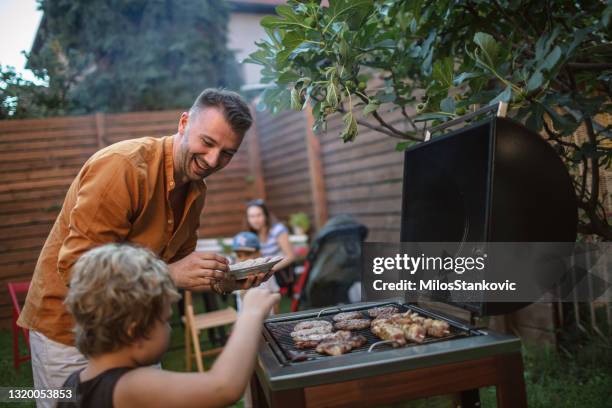 family barbecue in backyard - grilled stock pictures, royalty-free photos & images