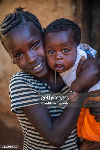 african girl carrying her younger brother, ethiopia, africa - traditional ethiopian girls imagens e fotografias de stock