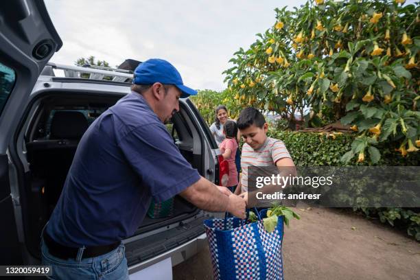 latinamerikansk familj anländer hem och lossar shoppingväskor från bilen - latin american and hispanic shopping bags bildbanksfoton och bilder