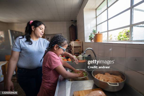 lateinamerikanische mutter lehrt ihre tochter zu kochen - poor man stock-fotos und bilder