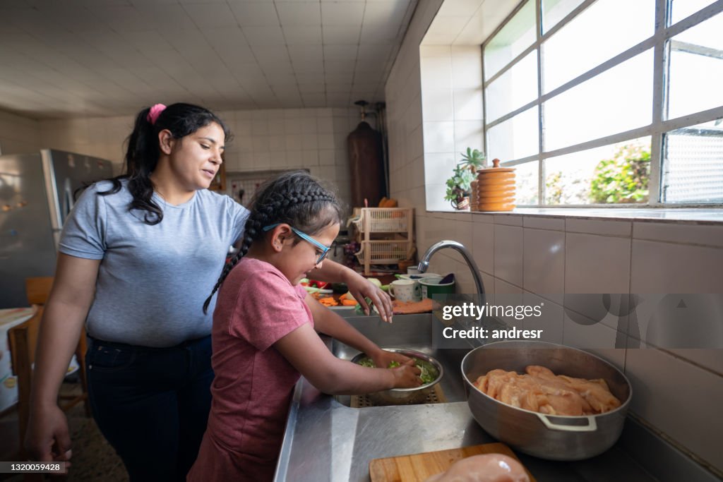 Latin American mother teaching her daughter to cook