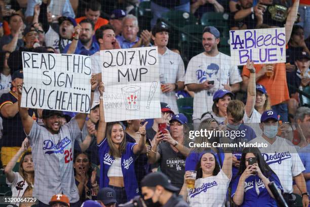 Fans hold sings during the first inning of a game between the Houston Astros and the Los Angeles Dodgers at Minute Maid Park on May 25, 2021 in...