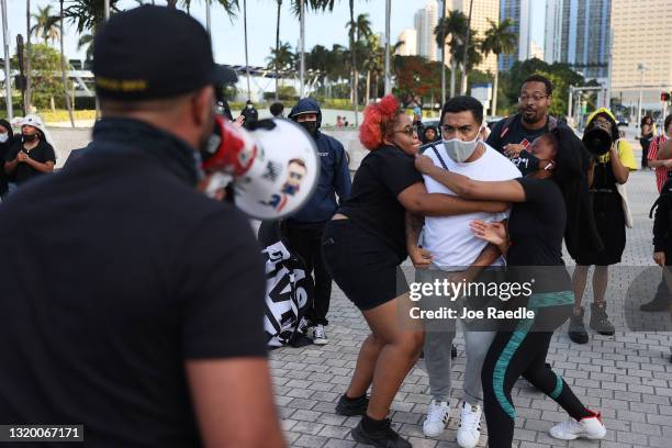 Man is held back as Enrique Tarrio , leader of the Proud Boys, uses a megaphone while counter-protesting people at the Torch of Friendship to...