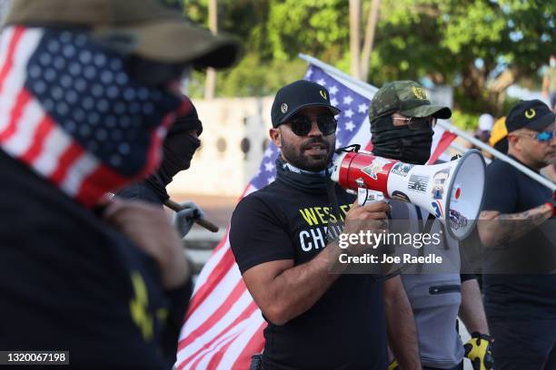 Enrique Tarrio , leader of the Proud Boys, uses a megaphone while counter-protesting people gathered at the Torch of Friendship to commemorate the...