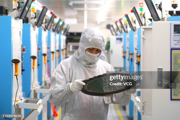 Employees work on the production line of silicon wafer at a factory of GalaxyCore Inc. On May 25, 2021 in Jiashan County, Jiaxing City, Zhejiang...