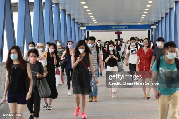 People wearing face masks cross an overpass on May 24, 2021 in Hong Kong, China.