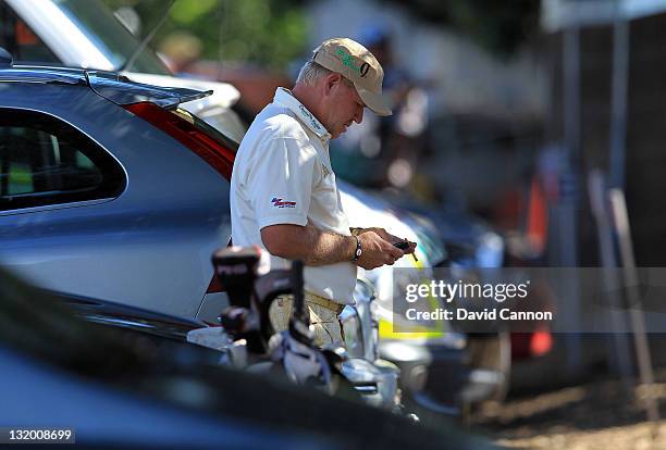 John Daly of the USA prepares to leave the course in a courtesy car after walking off the course in a rage at the 11th hole during day one of the...