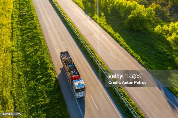aerial view of truck with metal for recycling  in rural landscape. - recycling rig imagens e fotografias de stock