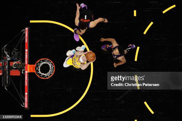 Alex Caruso of the Los Angeles Lakers slam dunks the ball past Devin Booker and Cameron Payne of the Phoenix Suns during the second half of Game Two...