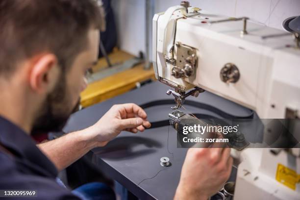 threading the sewing machine to set up for repairs in workshop - sewing machine stock pictures, royalty-free photos & images