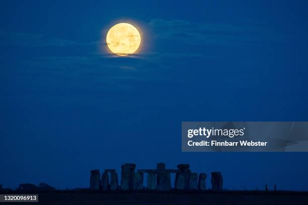 The Flower Moon sets over Stonehenge on May 26, 2021 in Amesbury, United Kingdom. May’s full moon, the “Flower Moon" will be the biggest and...