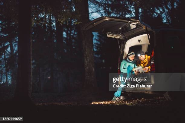 pitch black outside and couple camping in the trunk of their car - car camping luggage stock pictures, royalty-free photos & images