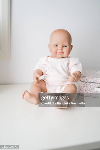 baby doll on white furniture - doll foto e immagini stock