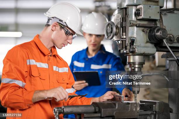 industrial technician working and control at a lathe machine with the supervisor standing at the side holding digital tablet in a factory. engineering part manufacturing concepts. - ranking member stock pictures, royalty-free photos & images