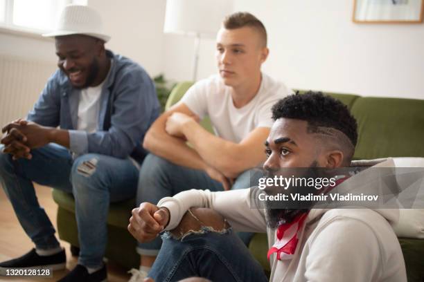 three men sitting close together watching television - aa meeting stock pictures, royalty-free photos & images