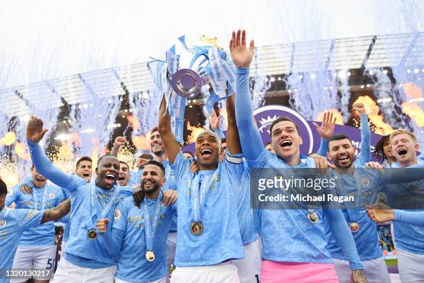 Fernandinho of Manchester City lifts the Premier League Trophy with team mates Benjamin Mendy, Riyad Mahrez, Ederson and Sergio Aguero as Manchester...