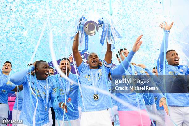 Fernandinho of Manchester City lifts the Premier League Trophy with team mates Benjamin Mendy, Riyad Mahrez, Ederson and Sergio Aguero as Manchester...