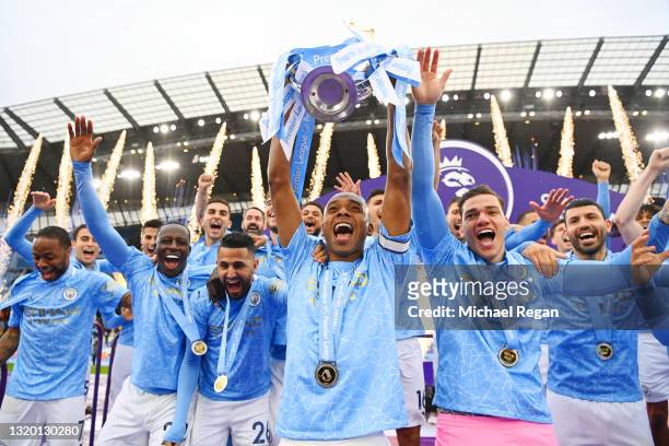 Fernandinho of Manchester City lifts the Premier League Trophy with team mates Benjamin Mendy, Riyad Mahrez, Ederson and Sergio Aguero as Manchester...