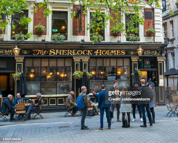 people eating and drinking outside sherlock holmes pub in london, uk - london pub stock pictures, royalty-free photos & images