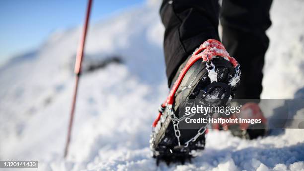 close-up of hiker walking in winter nature, crampons on boots. - steigeisen stock-fotos und bilder