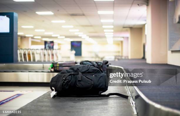 suitcase or baggage on luggage conveyor belt in an arrivals lounge of airport termina - baggage claim stock pictures, royalty-free photos & images