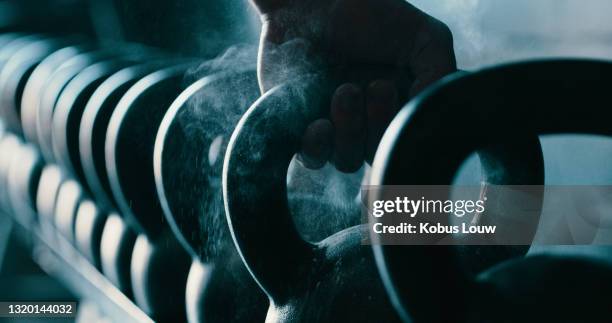 cropped shot of an unrecognizable man picking up a kettlebell - kettle bell stock pictures, royalty-free photos & images