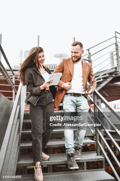 modern businessman and girlfriend talking about project while walking down stairs - woman signing stock pictures, royalty-free photos & images