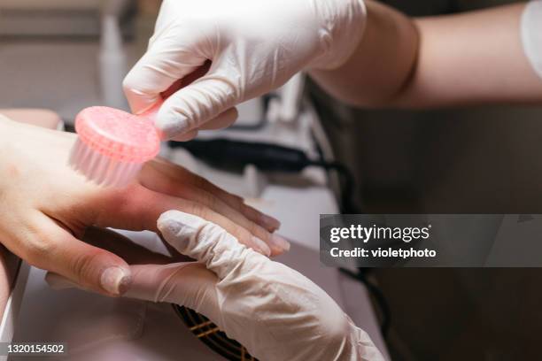 manicure master using brush to remove dust in the beauty salon - coronavirus moldova stock pictures, royalty-free photos & images