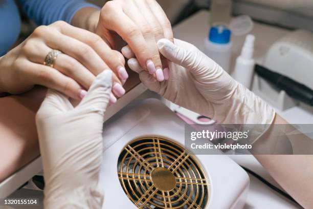 manicure master examines women's nails in beauty salon - coronavirus moldova stock pictures, royalty-free photos & images