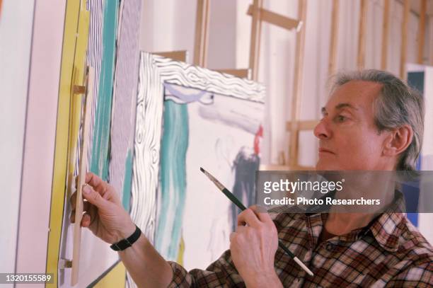 American Pop artist Roy Lichtenstein as he paints in his studio, New York, New York, 1984.