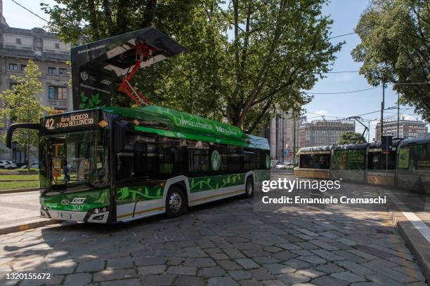 Cable car rides past a “Solaris Urbino 12” full electric bus, manufactured by Polish company Solaris, while connecting to a pantograph and charging...