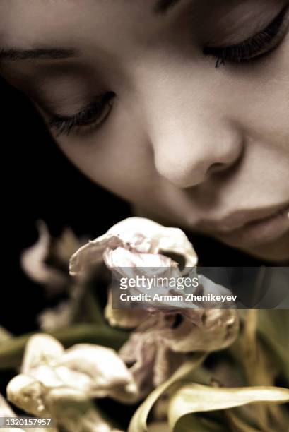pensive woman smelling wilted rose - dead women stock pictures, royalty-free photos & images