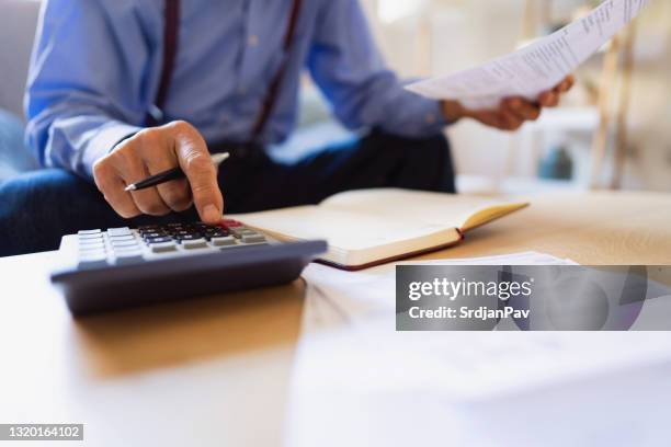 close-up of an unrecognizable man calculating his finances - 401k statement stock pictures, royalty-free photos & images