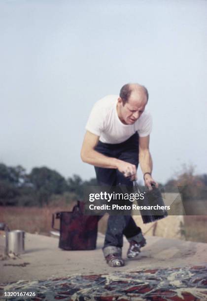 American abstract expressionist artist Jackson Pollock works on a painting at his Long Island studio, New York, 1950.