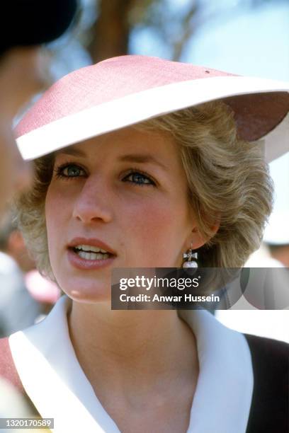 Diana, Princess of Wales, wearing a maroon dress with a white collar designed by Catherine Walker and a hat by Frederick Fox, during a visit to...