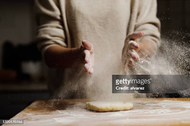 woman making tart dough in kitchen - sprinkling imagens e fotografias de stock