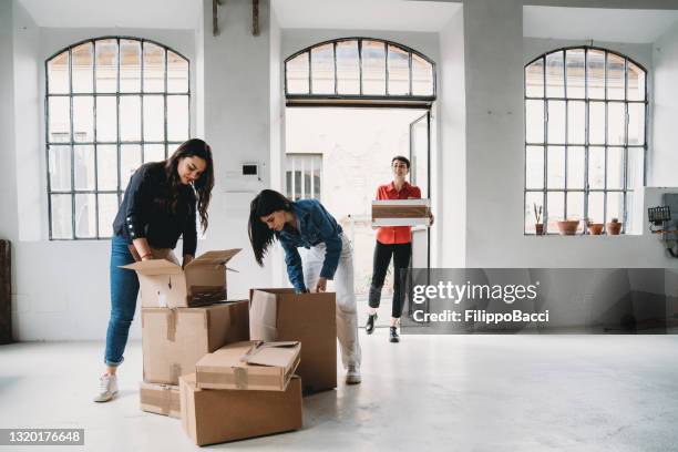 three colleagues are moving into their new office - day 1 stock pictures, royalty-free photos & images