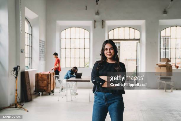 portrait of a young woman in a modern loft - new business stock pictures, royalty-free photos & images