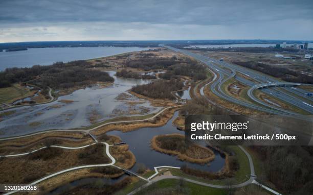 high angle view of river amidst landscape against sky,blanchardpad,almere,netherlands - almere stockfoto's en -beelden