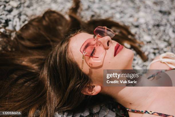 headshot of a woman lying on the beach - wavy hair beach stock pictures, royalty-free photos & images