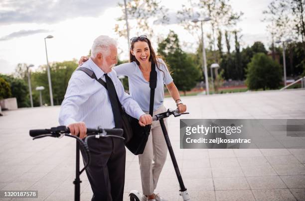 business man  and businesswomen with electric push scooter in the city - elderly scooter stock pictures, royalty-free photos & images