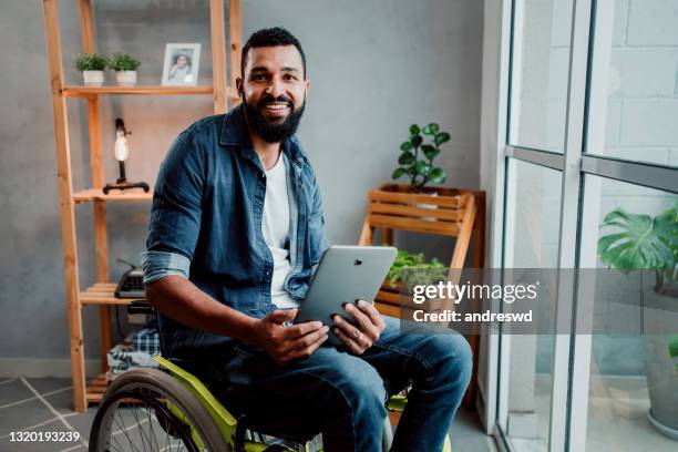 man in a wheelchair using digital tablet - man wheel chair stock pictures, royalty-free photos & images