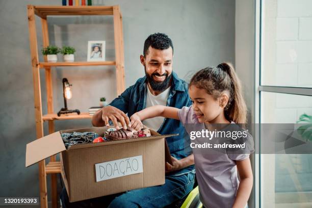 father in wheelchair and daughter preparing donation box for clothes - father and children volunteering imagens e fotografias de stock