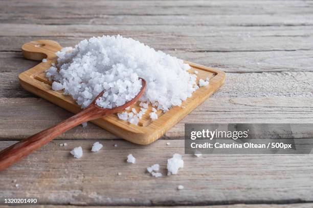 close-up of sugar in wooden spoon on table - salt stockfoto's en -beelden