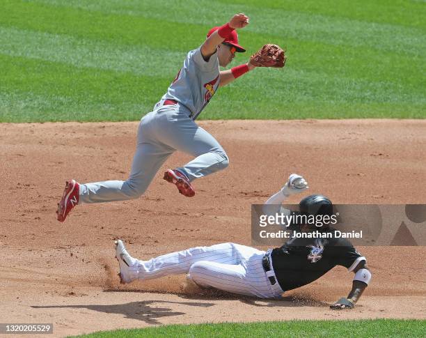 Tommy Edman of the St. Louis Cardinals leaps to avoid Yoan Moncada of the Chicago White Sox as Moncada steals second base in the 1st inning at...