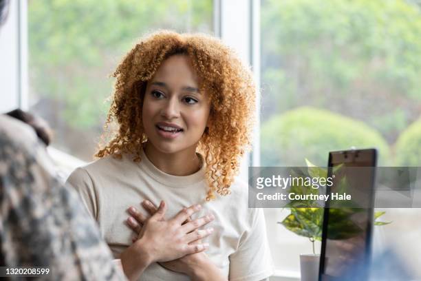 young adult military woman listening during one on one therapy session - two bank managers talking stock pictures, royalty-free photos & images